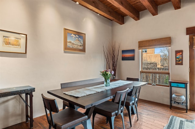 dining space with beamed ceiling, wood ceiling, and wood-type flooring