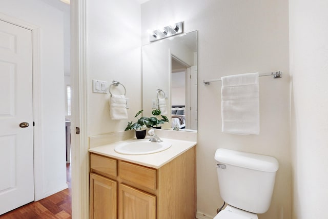 bathroom featuring vanity, toilet, and wood finished floors