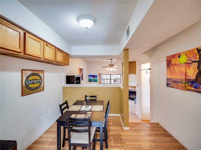 dining space with light hardwood / wood-style floors and ceiling fan