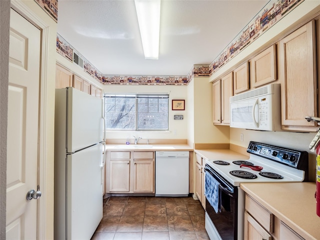 kitchen featuring sink, white appliances, and light brown cabinetry