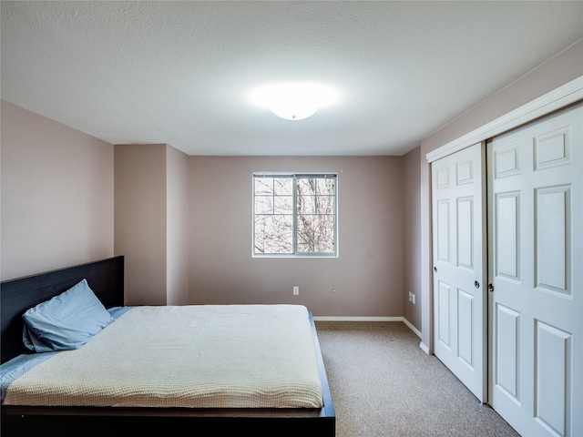 carpeted bedroom with a textured ceiling and a closet