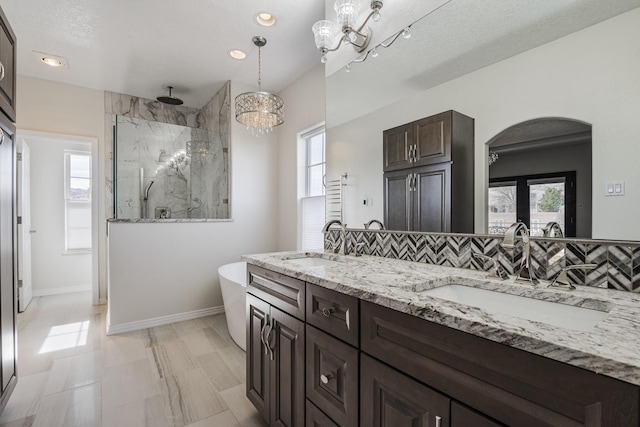 full bathroom with a sink, a marble finish shower, plenty of natural light, and tasteful backsplash