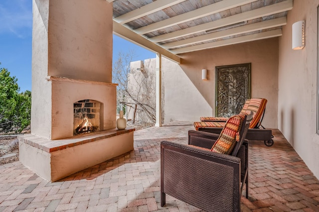 view of patio with a warm lit fireplace