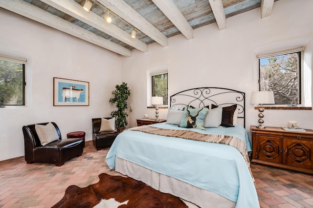 bedroom with wood ceiling, brick floor, and beam ceiling