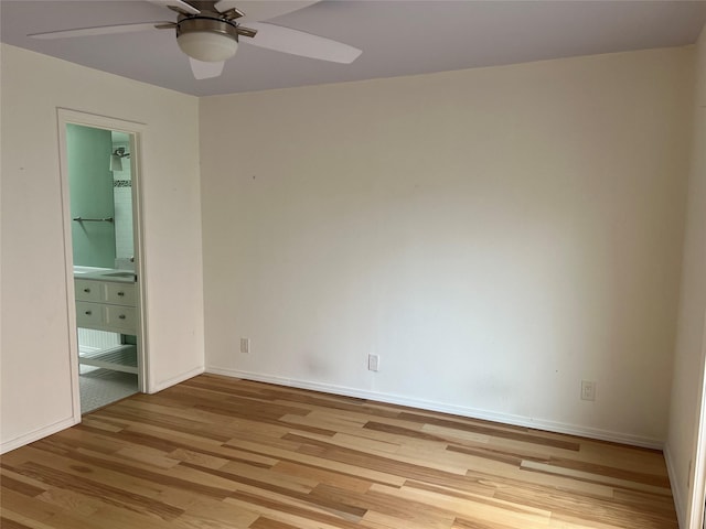 unfurnished bedroom featuring light wood finished floors, ensuite bath, baseboards, and ceiling fan