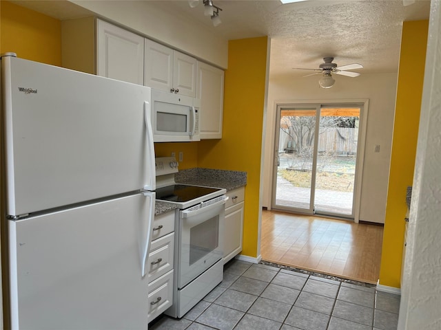 kitchen featuring light tile patterned floors, a ceiling fan, white cabinetry, a textured ceiling, and white appliances