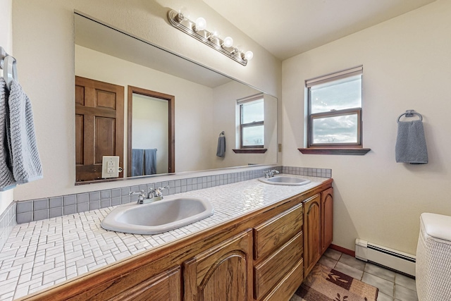 bathroom with double vanity, tile patterned flooring, baseboard heating, and a sink