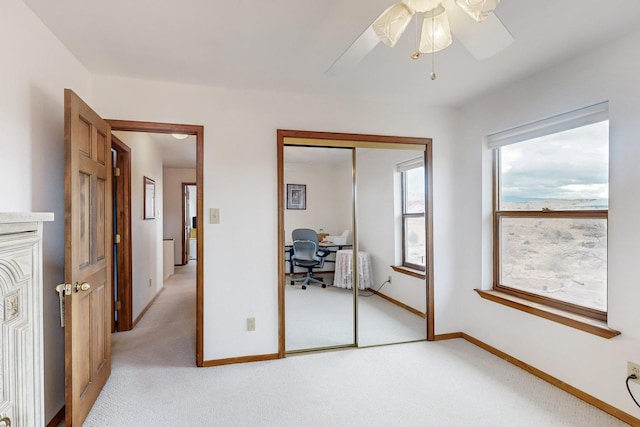 bedroom with baseboards, a closet, a ceiling fan, and light colored carpet