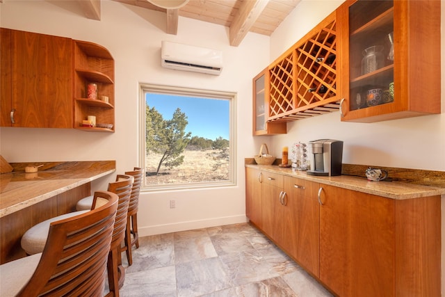 kitchen featuring a wall unit AC, light stone countertops, glass insert cabinets, and beam ceiling