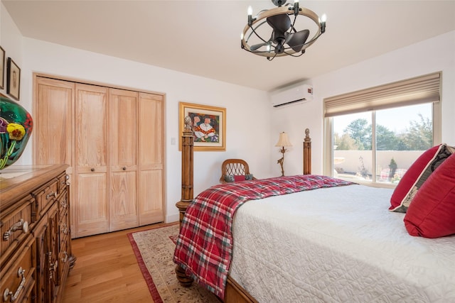 bedroom with light wood-style floors, access to exterior, and a wall mounted AC