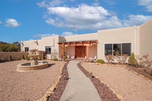 view of front of property with fence and stucco siding