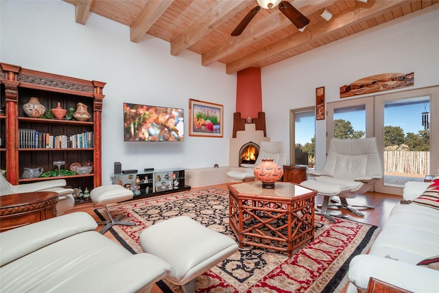 living area with wood ceiling, beam ceiling, a ceiling fan, and wood finished floors