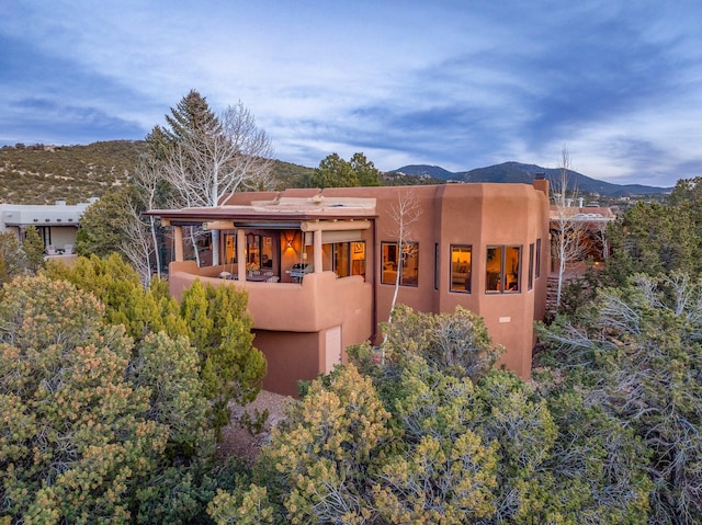 rear view of house featuring a mountain view and stucco siding