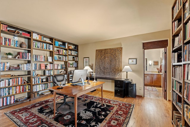 972 Indian Ridge Rd, Santa Fe, NM 87501 - home office featuring wall of books and wood finished floors