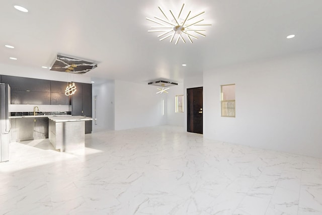 unfurnished living room with marble finish floor, a sink, and recessed lighting