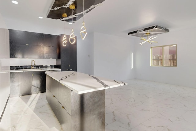 kitchen featuring marble finish floor, modern cabinets, a kitchen island, and light countertops