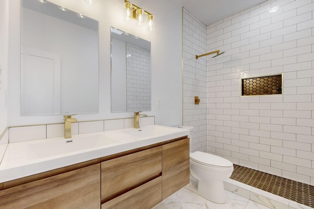 bathroom featuring toilet, marble finish floor, double vanity, and a sink