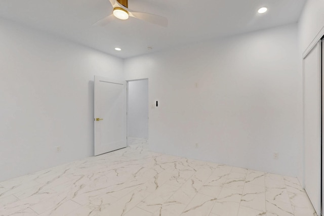 spare room with marble finish floor, a ceiling fan, and recessed lighting