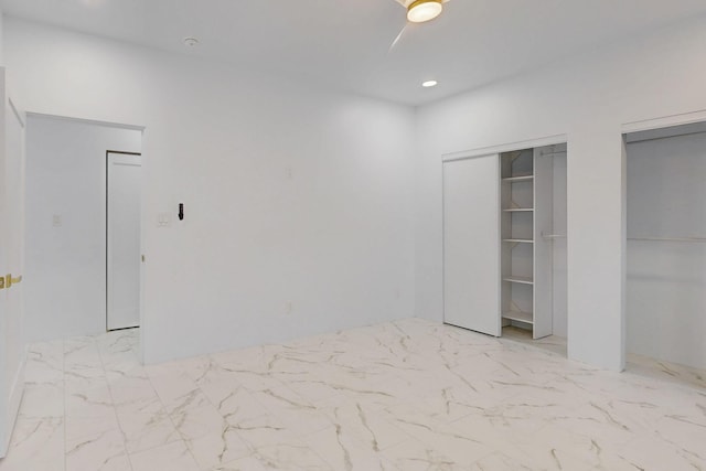 unfurnished bedroom with marble finish floor, two closets, and recessed lighting