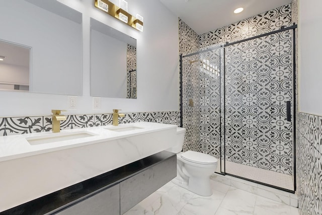 bathroom with marble finish floor, a stall shower, a sink, and toilet