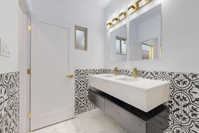 bathroom featuring marble finish floor, a sink, and double vanity