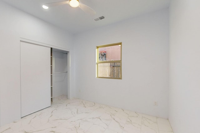 unfurnished bedroom featuring ceiling fan, marble finish floor, a closet, and visible vents