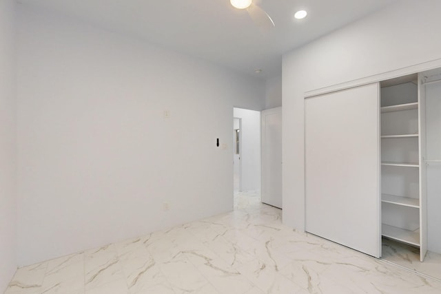 unfurnished bedroom with marble finish floor, a closet, a ceiling fan, and recessed lighting