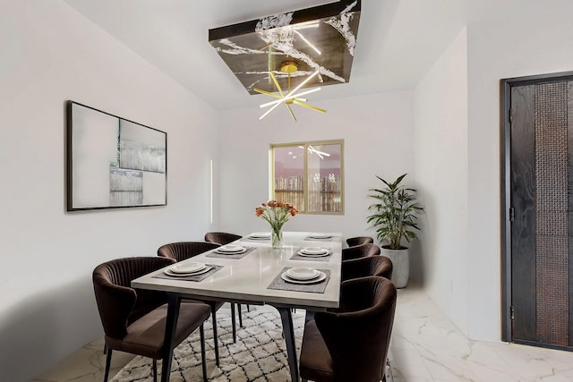 dining area featuring marble finish floor and a notable chandelier