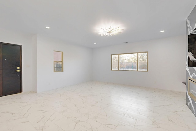 unfurnished room featuring recessed lighting and marble finish floor