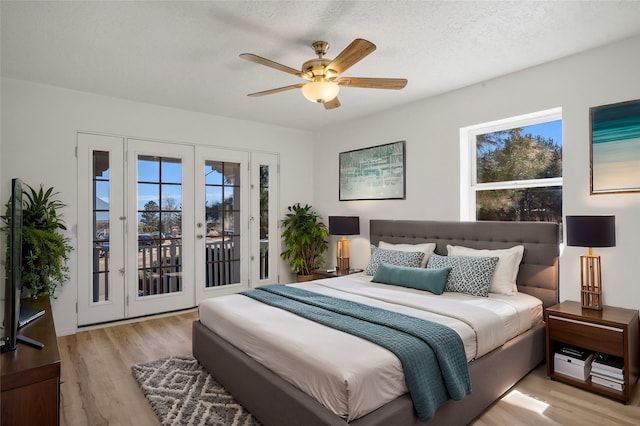 bedroom featuring a textured ceiling, access to outside, a ceiling fan, and light wood-style floors