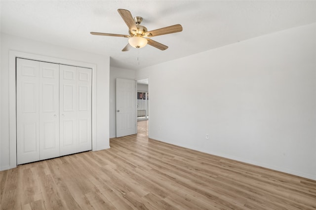 unfurnished bedroom featuring ceiling fan, light wood finished floors, a closet, and baseboards