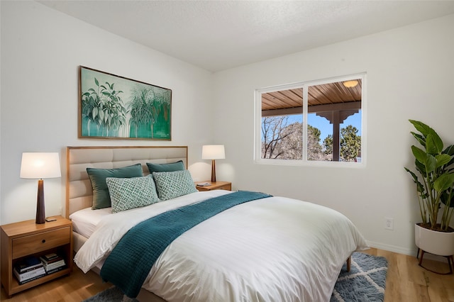 bedroom with light wood-type flooring and baseboards