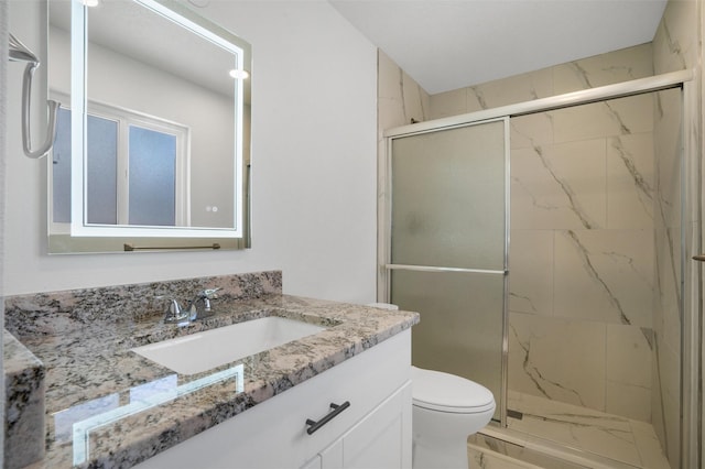 bathroom featuring a marble finish shower, vanity, toilet, and marble finish floor