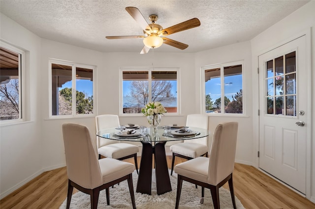 dining area featuring light wood-type flooring, plenty of natural light, and baseboards