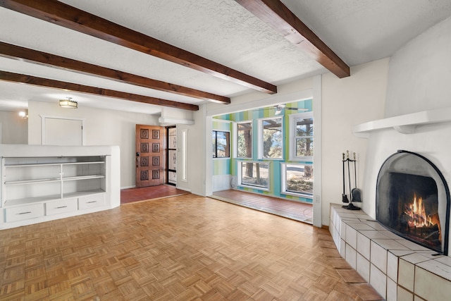 unfurnished living room featuring a warm lit fireplace, a textured ceiling, and beamed ceiling