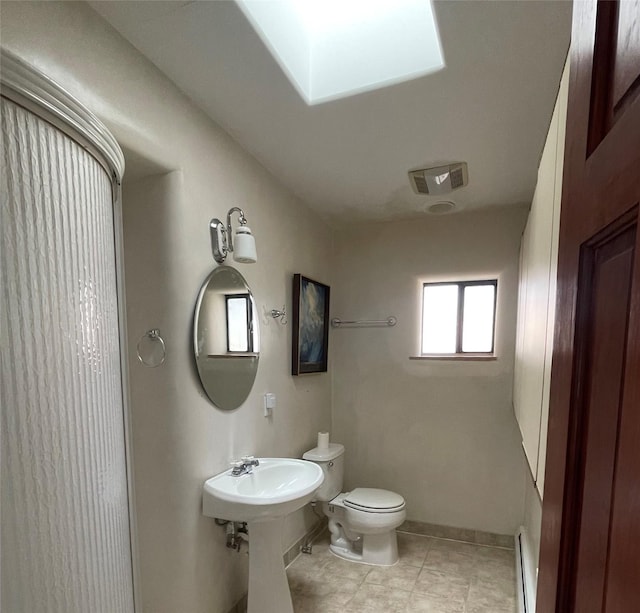 bathroom with tile patterned flooring, baseboards, toilet, and baseboard heating