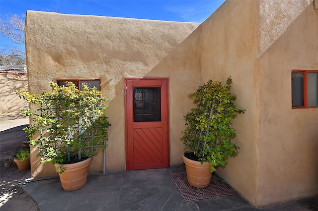 view of exterior entry featuring stucco siding