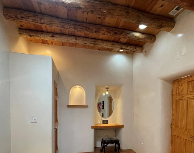 hallway featuring wood ceiling, visible vents, and beam ceiling