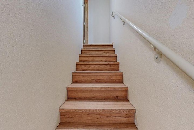 stairs featuring a textured wall