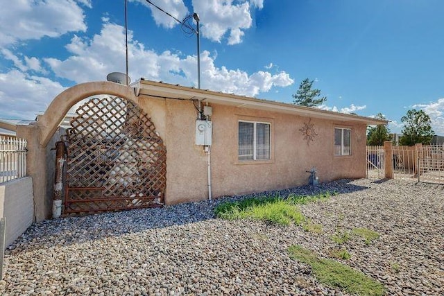 view of property exterior featuring fence and stucco siding