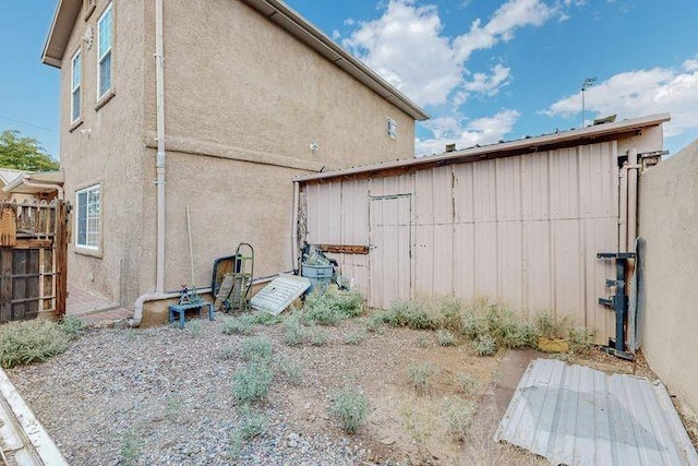 view of side of property featuring fence and stucco siding