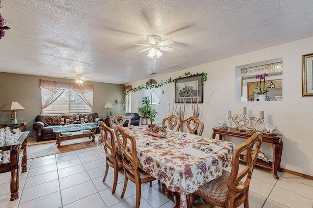 dining room with light tile patterned floors, a textured ceiling, baseboards, and a ceiling fan