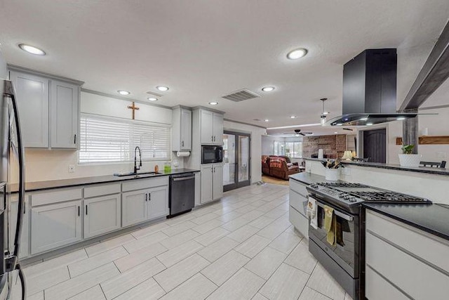 kitchen with gas range oven, dark countertops, gray cabinets, a sink, and dishwashing machine