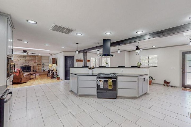 kitchen with island exhaust hood, gray cabinets, visible vents, gas stove, and open floor plan