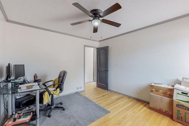 office featuring ornamental molding, visible vents, a textured ceiling, and wood finished floors