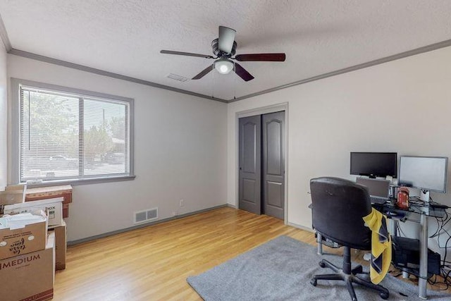 office area with visible vents, ceiling fan, a textured ceiling, crown molding, and light wood-style floors