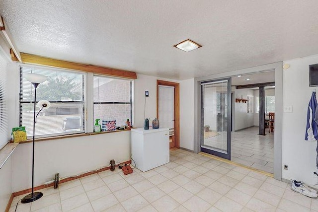 empty room featuring a textured ceiling and baseboards