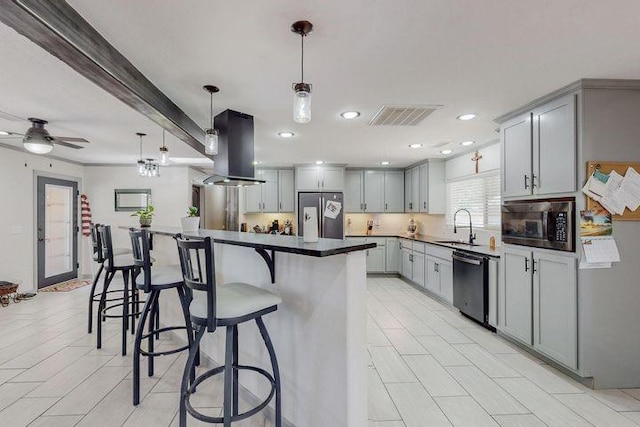 kitchen featuring island range hood, appliances with stainless steel finishes, gray cabinets, and a sink