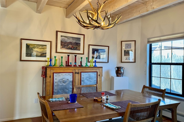 dining area with a baseboard heating unit, a notable chandelier, beam ceiling, and a healthy amount of sunlight