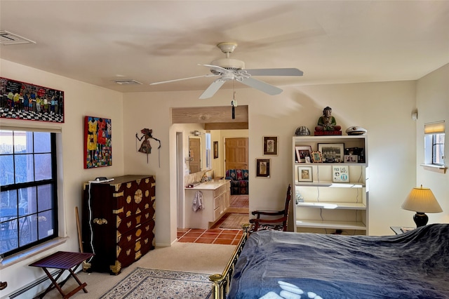 bedroom with ceiling fan, baseboard heating, and visible vents